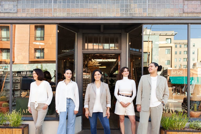 Group of people standing outside a storefront.