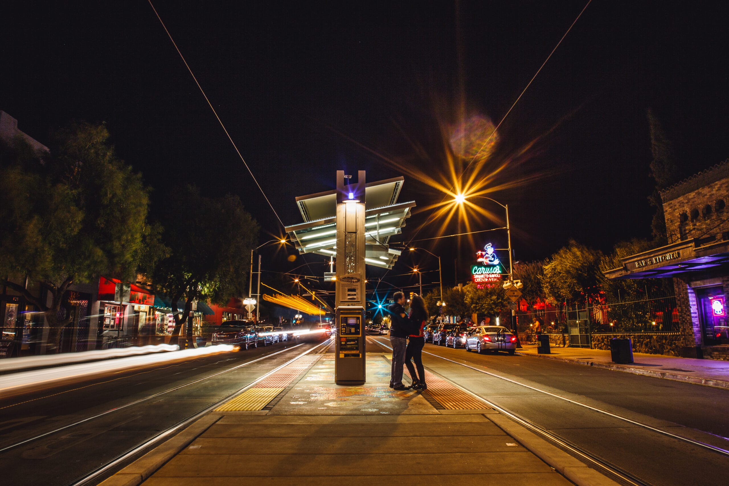 Couple at night tram station with neon lights