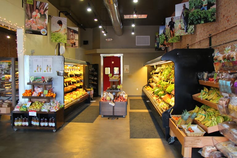 Grocery store produce section with fresh fruits and vegetables.
