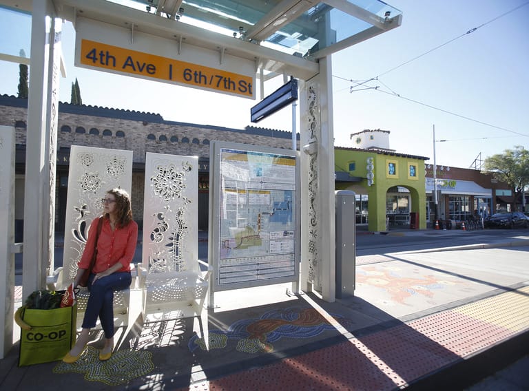 Person sitting at a city transit stop