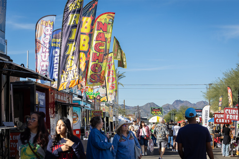 Busy outdoor food festival with colorful flags