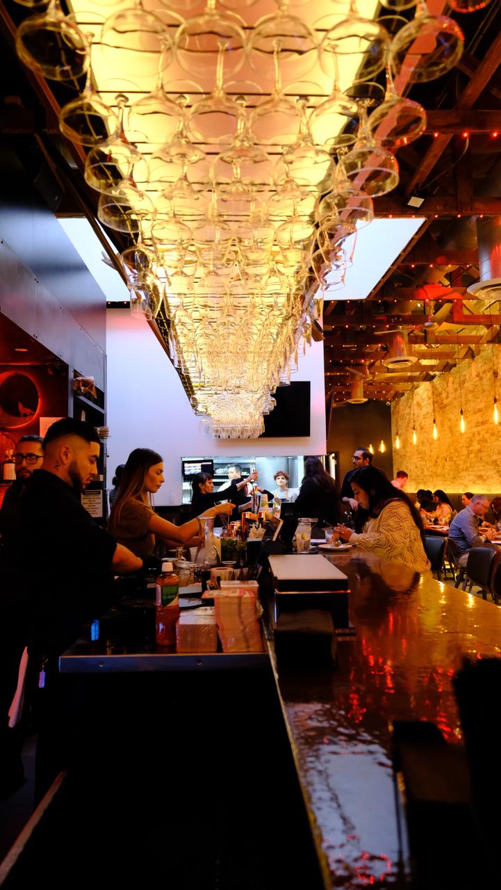 Bar with hanging glasses and patrons